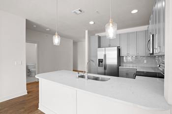 A modern kitchen with a white countertop and stainless steel appliances.